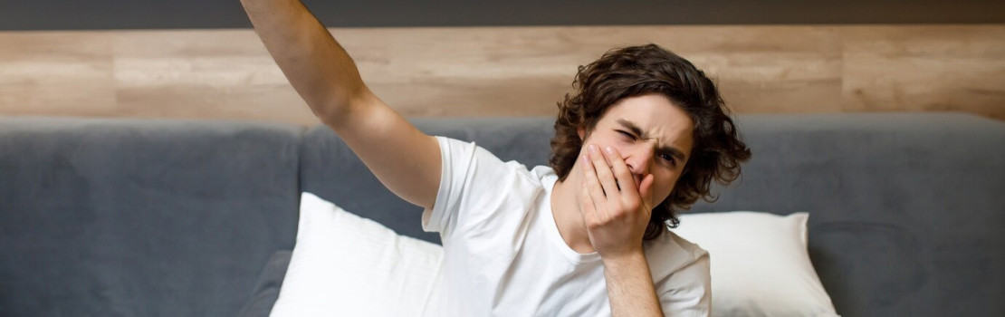 Žena v posteli s ťažkosťami zaspať a balenie melatonínu na nočnom stolíku