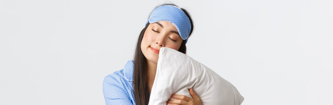 Žena ležiaca na vankúši s doplnkom Zerex Pillow na nočnom stolíku, symbolizujúca pokojný hlboký spánok