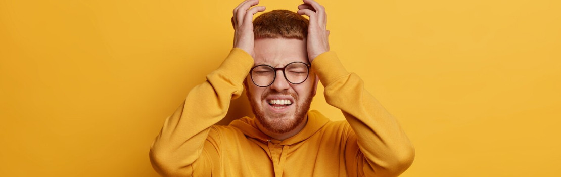 Stresovaný človek držiaci si hlavu v dlaniach, symbolizujúci duševné napätie