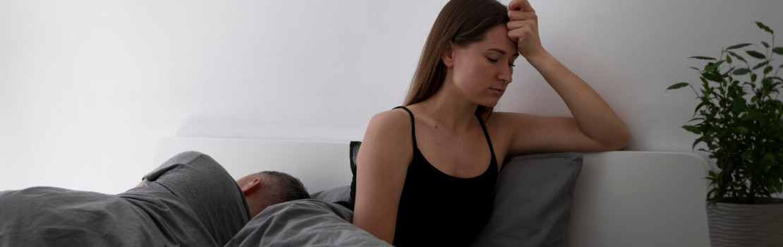 Záber unavenej osoby sediacej s hlavou v rukách a návrh riešení ako relax, pohyb a Ashwagandha