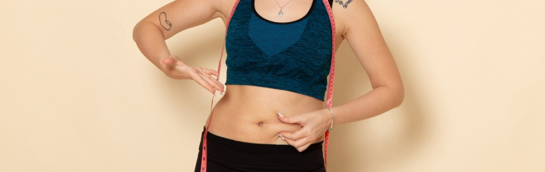 Žena nalepujúca náplasť na chudnutie na brucho