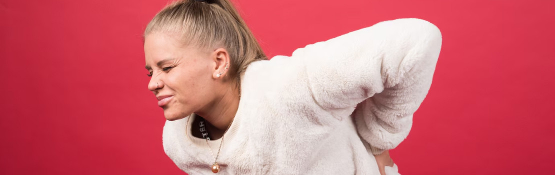 Ilustrácia bolestivého spojenia brucha a chrbta s bylinkami na úľavu